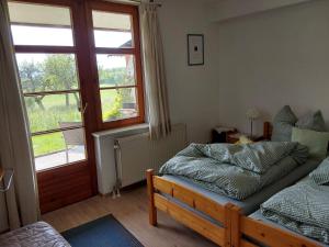 een slaapkamer met een bed, een raam en een deur bij Alpenblick in Nordschwaben