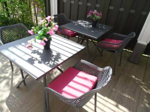 2 mesas y sillas con flores en un patio en B & B De Elsterberg en Elst