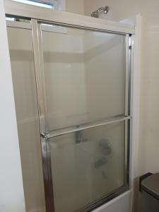 een douche met een glazen deur in een badkamer bij Cozy private rooms in Jonesboro +7 foto's