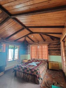 a bedroom with a bed in a room with wooden ceilings at Mt.Narsing Village Resort in Ravangla