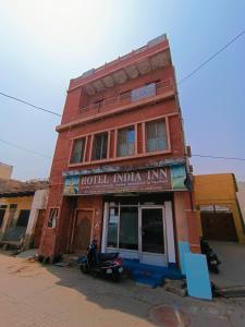 een gebouw met een motor die ervoor geparkeerd staat bij Hotel India inn in Agra