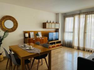 a living room with a dining room table and a television at Travel Habitat - Ciudad de las Ciéncias in Valencia