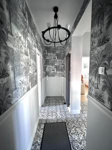 um corredor com piso em azulejo e um lustre em Przy plaży Apartament BURZA em Międzyzdroje