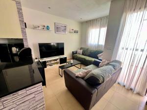 a living room with a couch and a television at CONDADO DE ALHAMA JARDIN 5 SV42 in El Romero