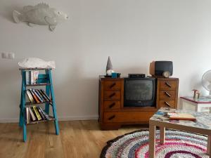 a living room with a tv and a wooden dresser at Casinha Azul in Horta