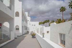 un edificio blanco con palmeras en el fondo en Calypso Fuerteventura, en Tarajalejo