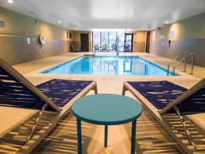 einen Pool mit einem blauen Tisch und einem Stuhl in der Unterkunft Home2 Suites By Hilton Bolingbrook Chicago in Bolingbrook