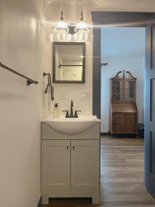 La salle de bains est pourvue d'un lavabo et d'un miroir. dans l'établissement Werner Room 204, Hyland Hotel, à Palmer