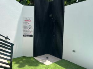 La salle de bains est pourvue d'une cabine en noir et blanc avec de l'herbe verte. dans l'établissement Stacys Place #4 Studio Apartment, à Port-d'Espagne