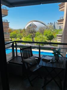 une chaise sur un balcon avec vue sur la piscine dans l'établissement Travel Habitat - Ciudad de las Ciéncias, à Valence