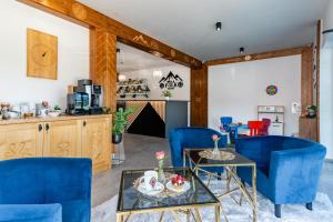 a living room with blue chairs and a table at Willa Folk Prestige in Zakopane