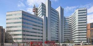 two double decker buses are parked in front of a building at Bright & Spacious Flat In London in Croydon