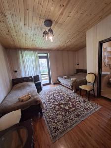 a bedroom with two beds and a rug at Guest House Kaldani in Mestia +17 photos