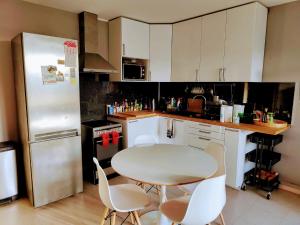 kuchnia ze stołem, krzesłami i lodówką w obiekcie Appartement confort Clichy JO 2024 w mieście Clichy
