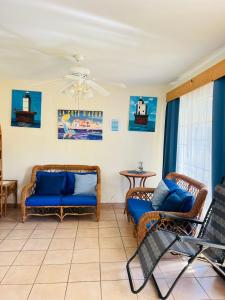 sala de estar con sillas de mimbre y sofá azul en villa en palma real en La Ceiba