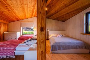 two beds in a room with wooden ceilings at Domek Trohaniec in Lutowiska