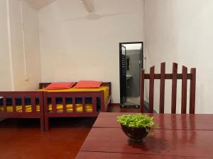 um quarto com uma cama, uma mesa e um espelho em Crystal Bay em Arugam Bay