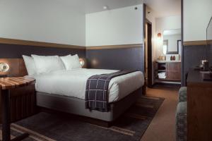 a bedroom with a large bed with a desk and a bed sidx sidx at The Ozarker Lodge in Branson