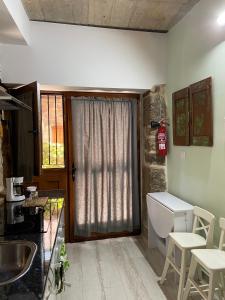 a kitchen with a sink and a toilet and a window at APARTAMENTO ESTUDIO AS ANDURIÑAS in San Martín de Trevejo
