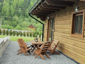 einen Picknicktisch und zwei Stühle auf der Veranda einer Hütte in der Unterkunft Chata Starý Mlyn in Habovka