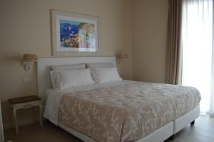 um quarto com uma cama branca e uma pintura na parede em B&B La Fiaba em Sirmione