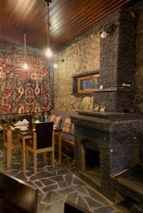 - un salon avec une cheminée, une table et un canapé dans l'établissement Guest House Nikala, à Mestia