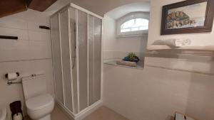 La salle de bains blanche est pourvue de toilettes et d'une fenêtre. dans l'établissement Cà da Ro, à Fezzano