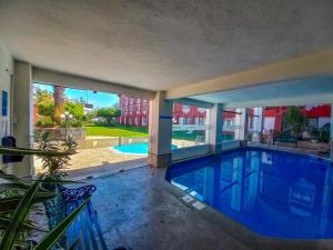 - une piscine avec vue sur un bâtiment dans l'établissement Fiesta Inn Xalapa, à Xalapa