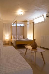 una camera con letto a baldacchino e tavolo di Poseidon Apartments and Villas by the Sea a Sounio