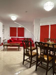 uma sala de estar com um sofá vermelho e uma mesa em Villa Jogia (πρώην ονομασία Villa Chanel em Marathos