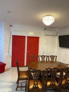 comedor con mesa y sillas y puerta roja en Villa Jogia (πρώην ονομασία Villa Chanel en Marathos