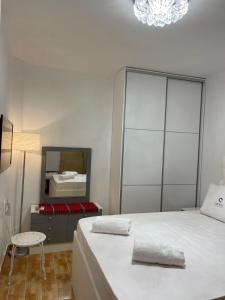 1 dormitorio con 1 cama con espejo y silla en Villa Jogia (πρώην ονομασία Villa Chanel en Marathos
