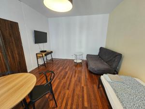 a living room with a couch and a chair and a table at FIRST -- Green Żoliborz apartment 3 in Warsaw