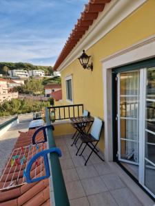 a patio with a table and chairs on a balcony at Porto Dinheiro Beach I in Lourinhã