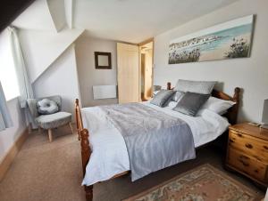 a bedroom with a large bed and a chair at Harbour House Holiday Home in Porlock