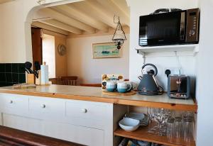 a kitchen with a counter top with a microwave at Harbour House Holiday Home in Porlock