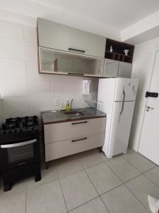 a kitchen with a white refrigerator and a stove at Studio Lupi in Sao Paulo