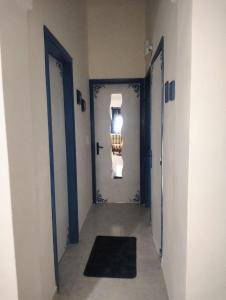 un couloir avec deux portes bleues et un tapis noir dans l'établissement Casa Vacanze da Francesca, à Realmonte