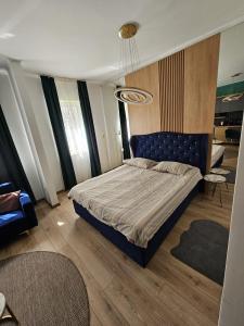 a bedroom with a bed with a blue headboard at Milan Luxury Apartaments I-Maurer Residence Târgu Mureș in Târgu-Mureş