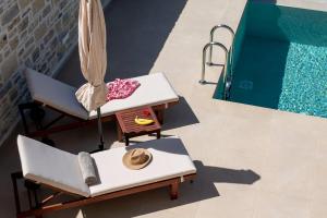 an overhead view of a pool with chairs and a table at Elxis luxury villas Salty Pools! in Kalochorafitis +44 photos