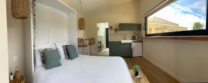una camera da letto con un letto bianco e una grande finestra di La parenthèse a Aubérives-sur-Varèze
