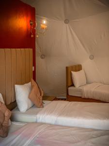 a room with two beds and a tent at Sama Rum Luxury Camp in Wadi Rum
