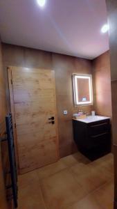 a bathroom with a wooden door and a sink at Noor Lux Apartments in Bad Hall