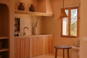 una cocina con armarios de madera y una ventana en Estel Formentera, en Playa de Migjorn