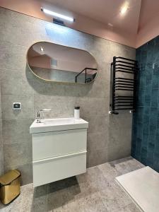 a bathroom with a sink and a mirror at Apartament Szafranowy in Wrocław