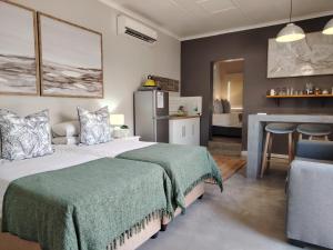 a bedroom with a bed and a desk and a kitchen at @Mango's in Beaufort West