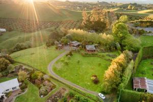 an aerial view of a house in a green field at Swiss-Kiwi Retreat A self-contained Appartment and a Tiny House option in Tauranga