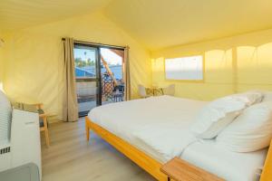 a bedroom with a large bed with a view of the ocean at Urban Oasis Luxe Glamping with King Bed & BBQ in Glendora
