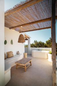 d'une terrasse avec une table en bois et un banc. dans l'établissement Estel Formentera, à Playa Migjorn