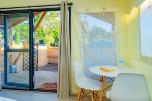 a room with a table and chairs and a sliding glass door at Urban Oasis Luxe Glamping with King Bed & BBQ in Glendora